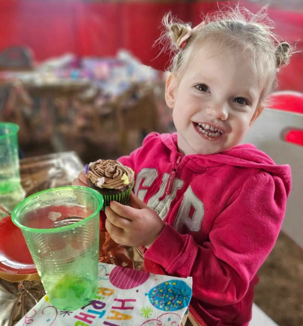 Little girl smiling with a cupcake